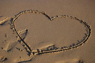 A love heart drawn on the sand.