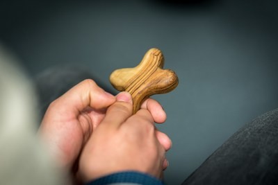 A person holds a cross in their hands.