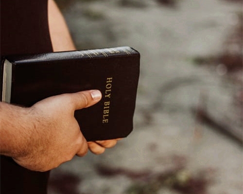 A man holds the Holy Bible in his hands.
