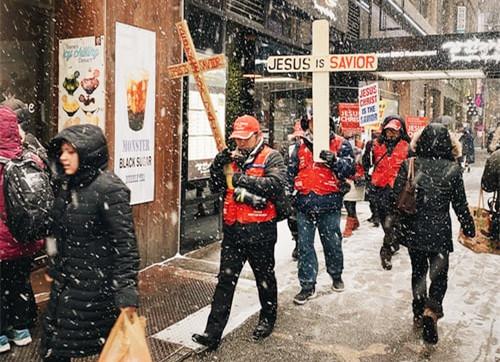 Christians held a cross stick proclaming "Jesus is Savior" on a street in unknown country.