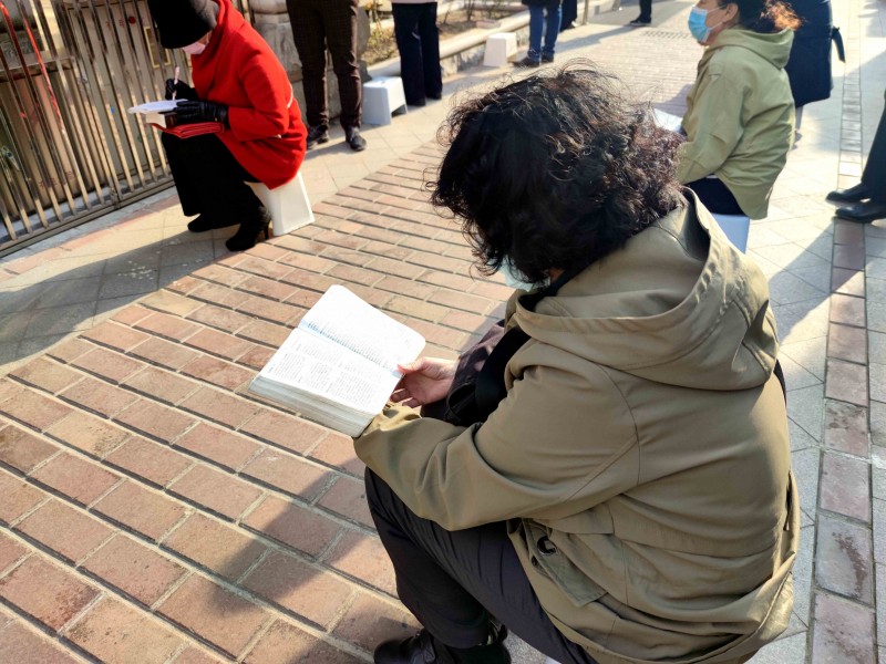 Some believers from Yuguang Street Church, Dalian, Liaoning, were seated down to read the Bible in the courtyard outside the sanctuary on April 11, 2021.