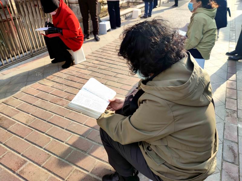 Some believers from Yuguang Street Church, Dalian, Liaoning, were seated down to read the Bible in the courtyard outside the sanctuary on April 11, 2021.