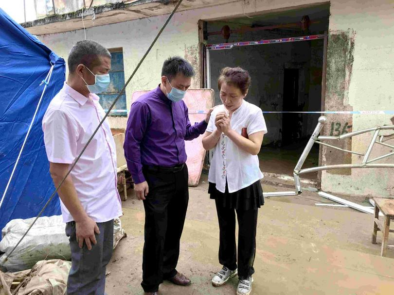 Pastor Liao Haomin, president and chairman of Suizhou CC&TSPM prayed with a flood-affected Christianf family in Junchuan Town, Suizhou, Hubei, on August 13, 2021.