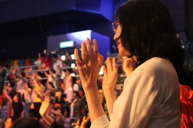 Believers raise their hands to praise God.