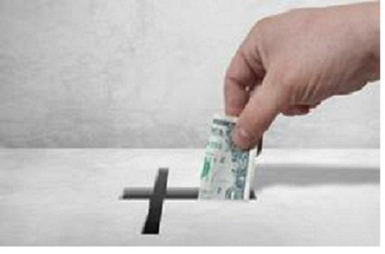 A man puts money into an offering box.