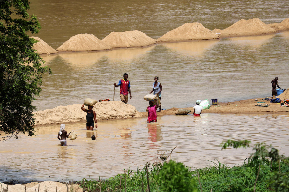 Families bathe and wash clothes in the Taia River, near Taiama, Sierra Leone. Churches are lobbying the government to limit water pollution caused by diamond and gold mining.
