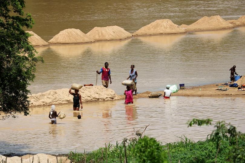 Families bathe and wash clothes in the Taia River, near Taiama, Sierra Leone. Churches are lobbying the government to limit water pollution caused by diamond and gold mining.