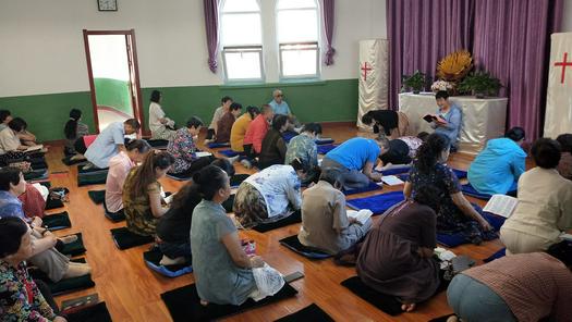 Christians listened to a female believer who shared the Bible on cushions during a morning prayer meeting in Pingliang Church, Gansu Province, in October 2021.