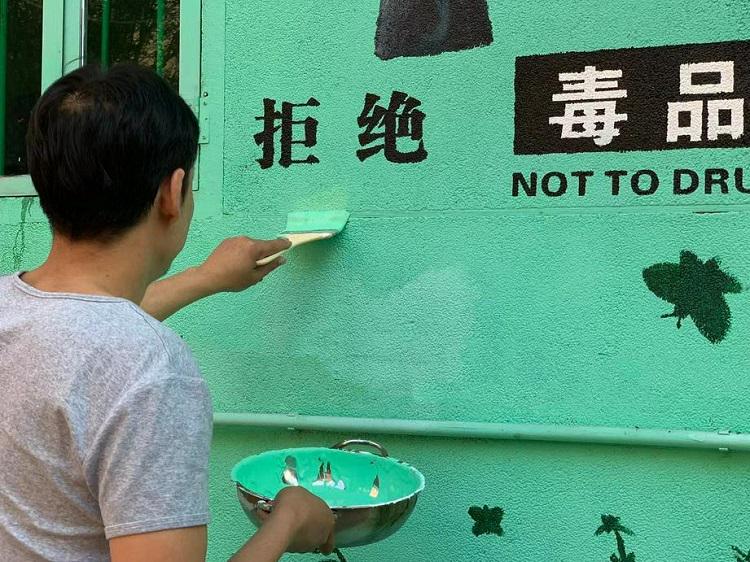 A former drug addict painted a wall with a sign saying "Not to Drugs" at an unknown day.
