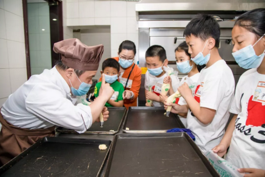An Amity Bakery worker with intellectual disablity in Nanjing, Jiangsu, taught children how to make cookie in 2019.