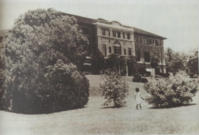 An old picture shows a girl standing before Hangchow University at an unknown date.