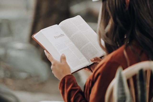 A picture shows a female believer reading the Bible.