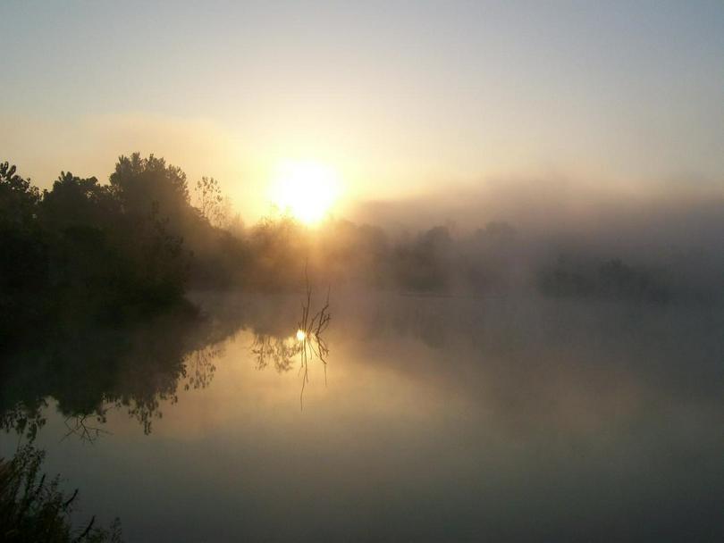A picture shows the sun reflected on the lake.