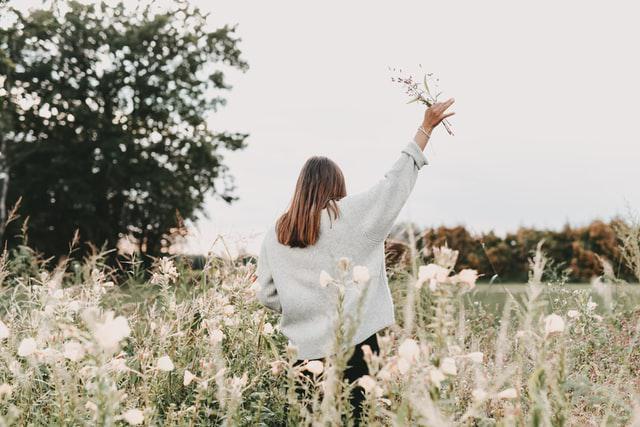 A picture shows a girl holding flowers in her hand.