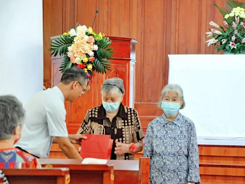 Senior Pastor Zhang Chengtao of Guangxiao Church in Guangzhou, Guangdong, presented a gift to a female aged believer during a Sunday service on September 11, 2022.