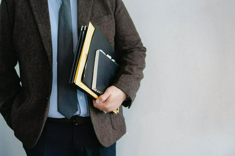 A picture shows a man holding some books.