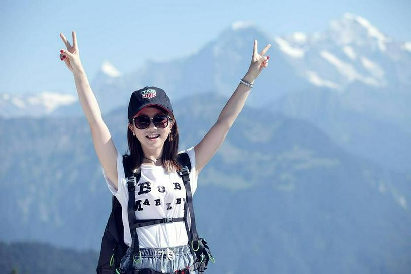 A picture shows a Christian singer G.E.M on a mountain.