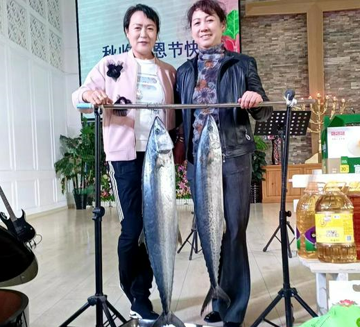 Two believers took a picture with two big fish after a Sunday service to celebrate the Autumn Harvest Festival in Shuishiying Church, Dalian, Liaoning, on October 16, 2022.