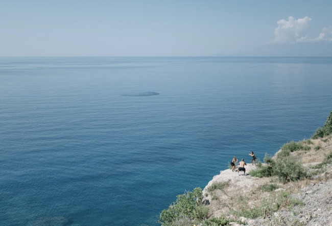 A picture shows three persons playing at the sea.