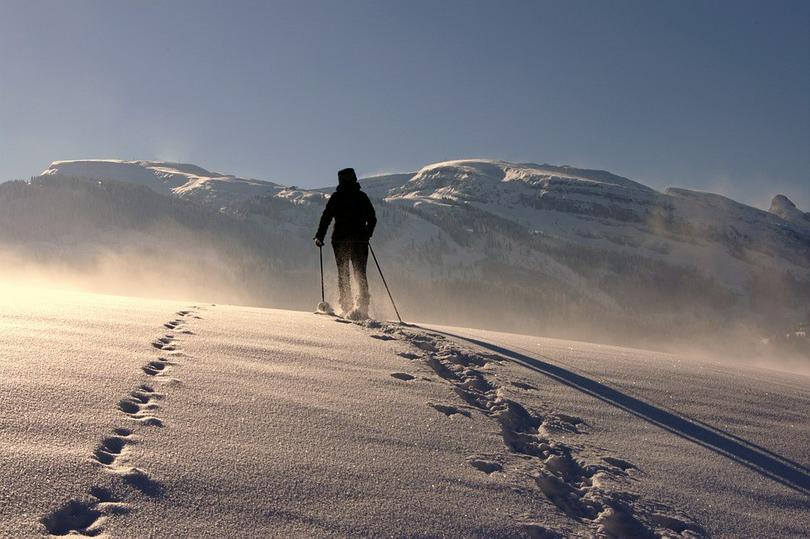 A picture shows a man walking on the snow