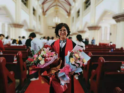 A picture shows Elder Chen Yu holding two bunches of flowers.