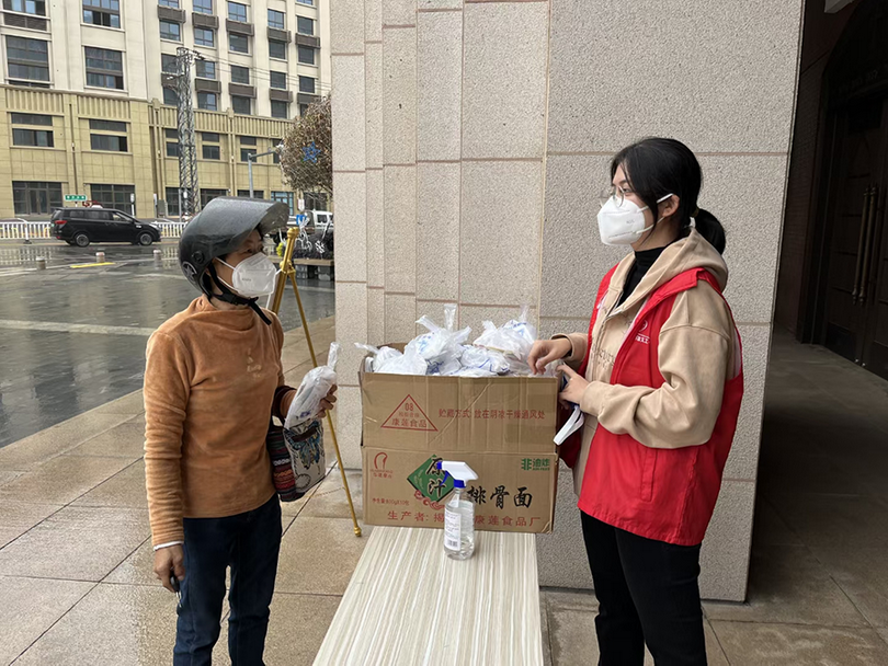 A female member of Beimen Church in Zhangzhou, Fujian, sent out a packet of three masks and a COVID-19 rapid antigen test kit to a passer-by at the gate of the church on January 10, 2023.